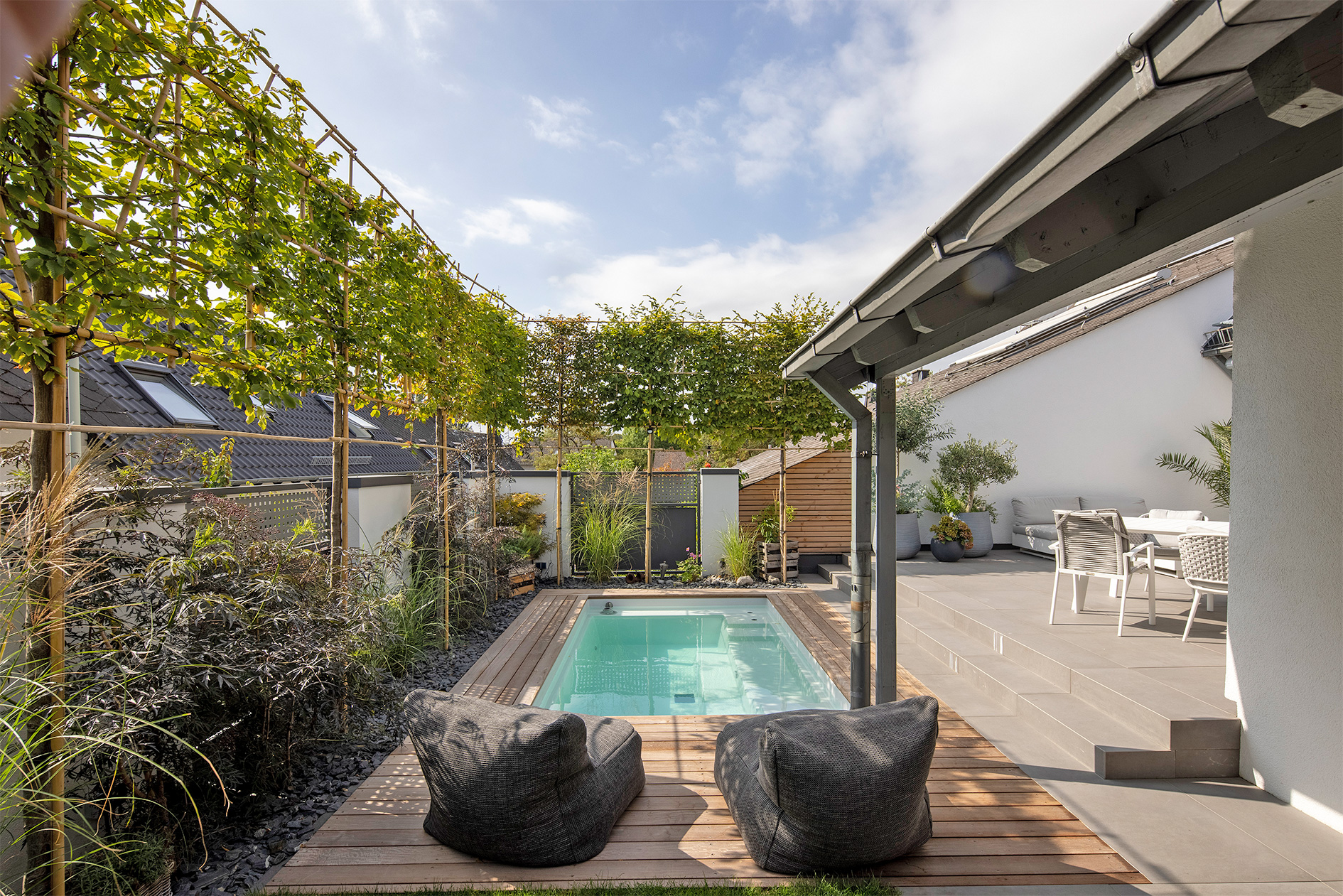 Pool mit Umrandung aus Holz und Lounge