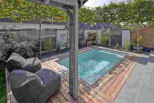 Pool mit Holzumrandung und Sichtschutz